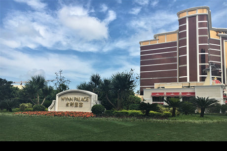 Landscape planting at the Wynn Palace entrance in Macau, with cordylines, cycads and clipped hedging over turf.